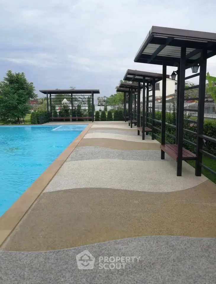 Luxurious outdoor pool area with modern pergolas and lush greenery, perfect for relaxation and leisure.