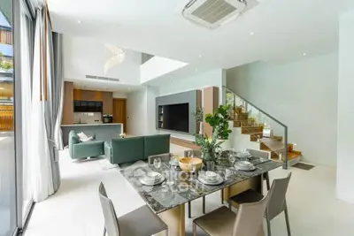 Luxurious open-plan living room with modern kitchen and elegant dining area, featuring a stylish staircase and ample natural light.