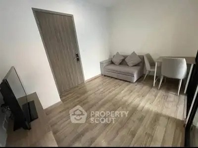 Modern living room with sleek furniture and wooden flooring in a cozy apartment.