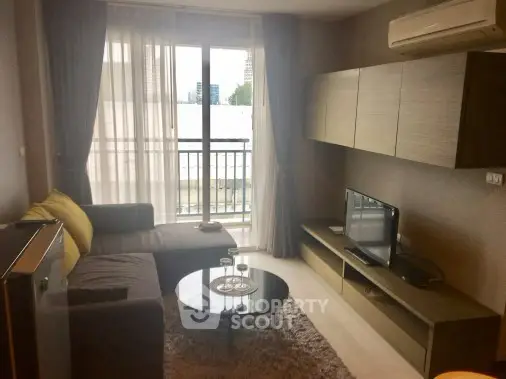 Cozy living room with modern furniture and balcony view in urban apartment.