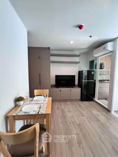 Modern living room with dining area and kitchen in open layout apartment.