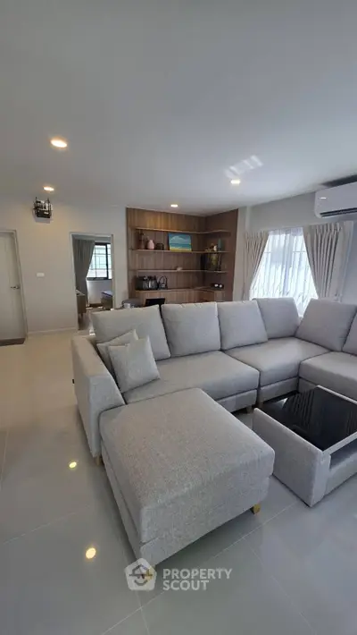 Spacious modern living room with stylish gray sectional sofa and elegant decor