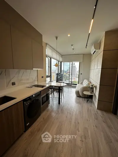 Modern open-plan kitchen and living area with city view and sleek design.