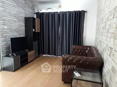 Modern living room with brick walls, leather sofa, and entertainment center.