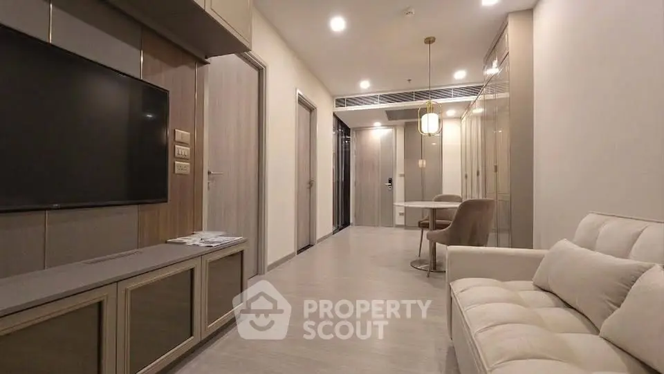 Modern living room with sleek design and neutral tones, featuring a comfortable sofa and wall-mounted TV.
