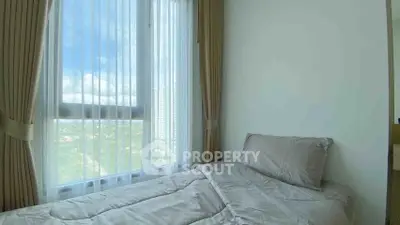 Cozy bedroom with large window offering stunning city views and natural light.