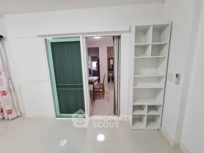 Modern apartment interior with sliding glass door and built-in shelving