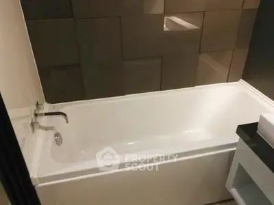 Modern bathroom with sleek bathtub and stylish tile design.