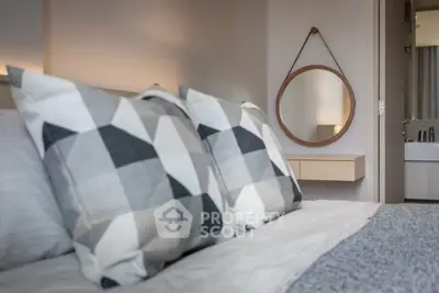 Modern bedroom with geometric pillows and stylish round mirror