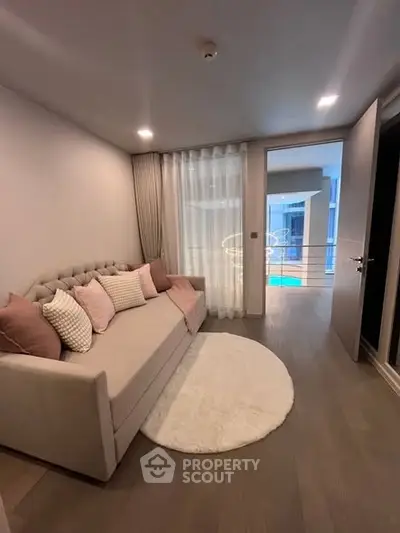Cozy living room with elegant sofa and modern decor, featuring a view of the pool area.