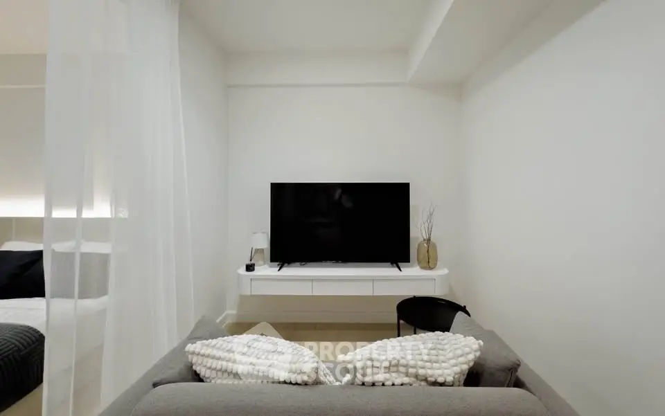 Modern living room with sleek TV setup and cozy sofa in minimalist design.