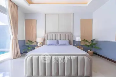 Luxurious bedroom with elegant decor and large windows offering natural light.