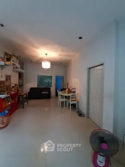 Spacious living room with modern chandelier and cozy seating area.