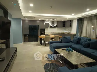 Luxurious modern living room with open kitchen, elegant decor, and spacious seating area.