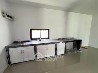 Modern kitchen with sleek black and white cabinetry and large window