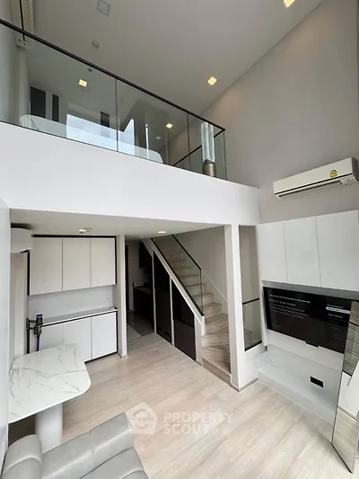 Modern loft apartment with mezzanine bedroom and sleek open kitchen design.