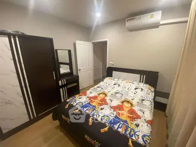 Cozy bedroom with anime-themed bedding and modern furniture, featuring air conditioning and ample storage space.