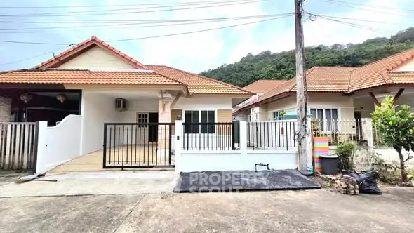 Charming suburban homes with tiled roofs and gated driveways in a peaceful neighborhood.