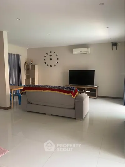 Spacious living room with modern decor and wall-mounted air conditioning unit.