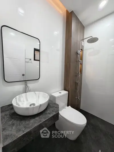 Modern bathroom with sleek fixtures and elegant marble sink in a contemporary design.
