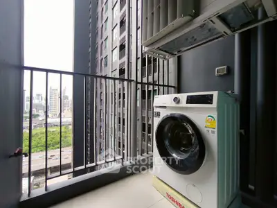 Modern balcony with washing machine and city view in high-rise apartment.