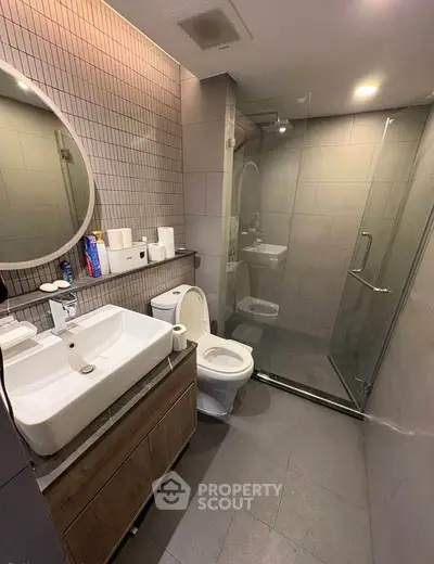 Modern bathroom with glass shower, sleek vanity, and contemporary fixtures.