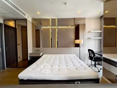 Modern bedroom with stylish decor, large mirror, and workspace in luxury apartment.
