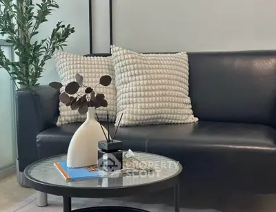 Modern living room with black leather sofa and stylish decor