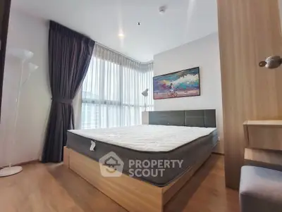 Modern bedroom with large windows and stylish decor in a high-rise apartment.