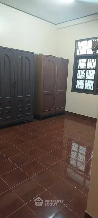 Spacious room with tiled floor and two large wardrobes, ideal for storage or bedroom setup.