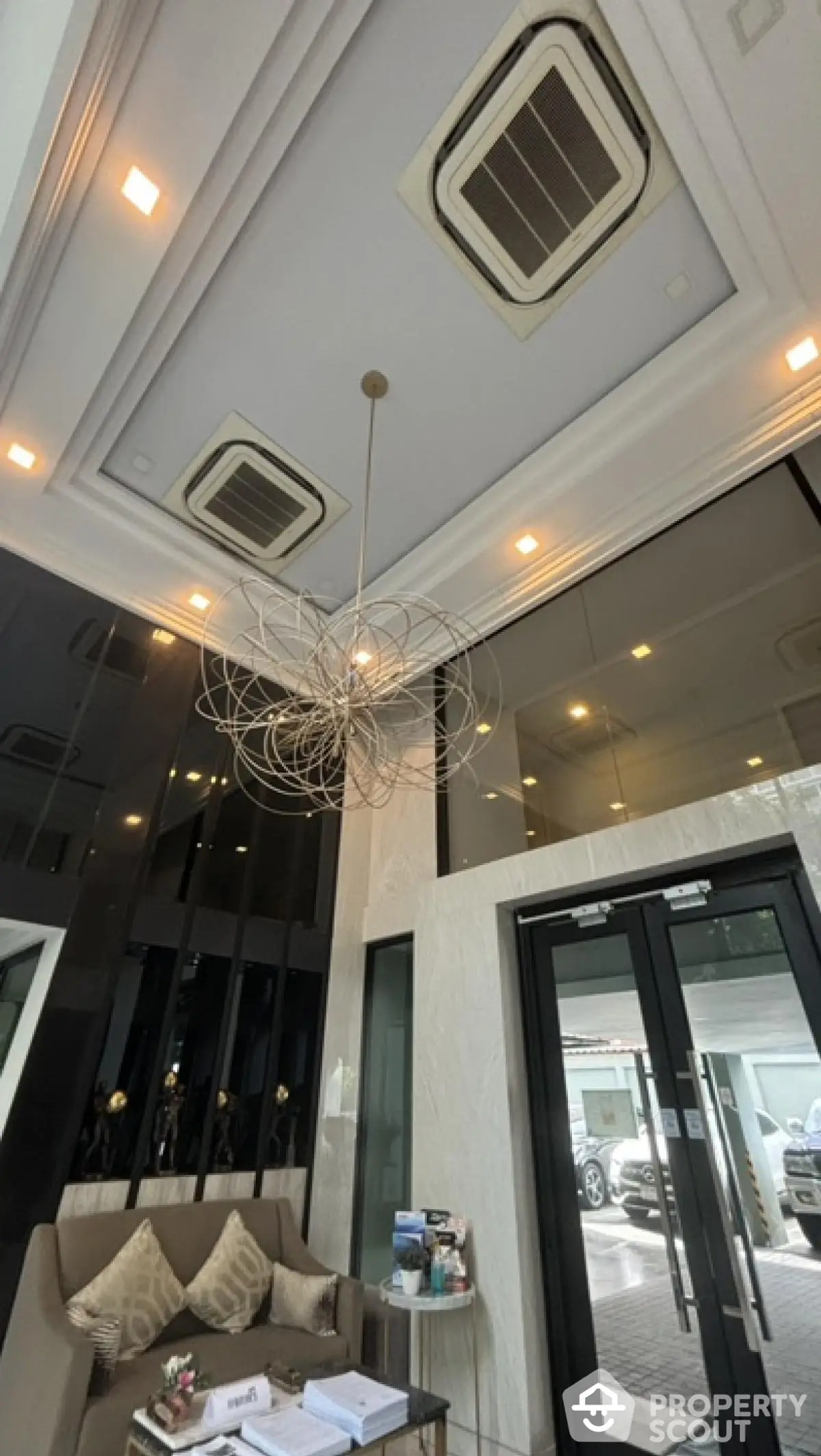 Elegant building entrance with modern chandelier and glass doors