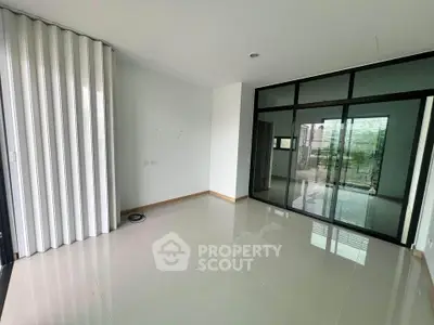 Spacious modern living room with glass doors and sleek flooring