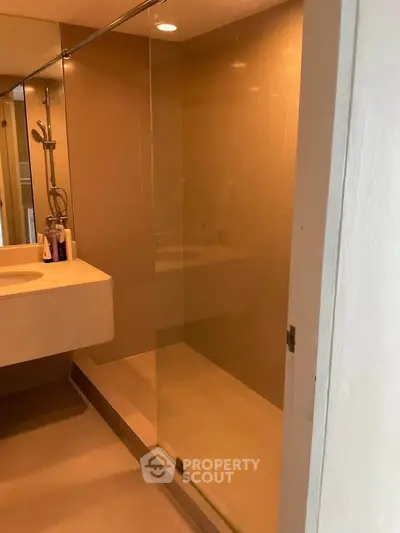 Modern bathroom with glass shower enclosure and sleek vanity in a contemporary home.