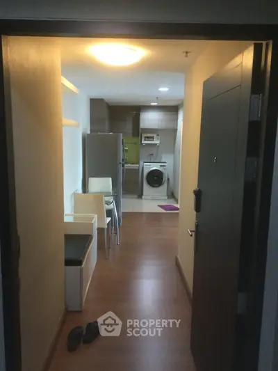 Cozy apartment entrance with modern kitchen and washing machine
