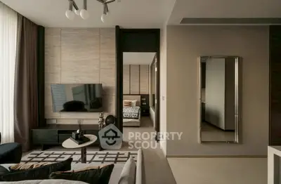 Modern living room with stylish decor and a glimpse into a cozy bedroom.