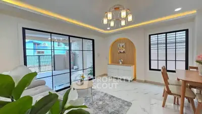 Modern living room with stylish lighting and large windows, featuring elegant decor and spacious layout.