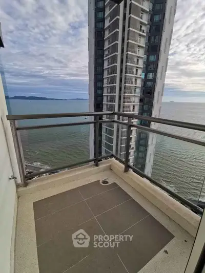 Stunning ocean view from high-rise balcony with modern glass railing