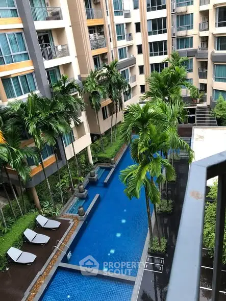 Luxurious apartment complex with stunning pool and lush greenery view.