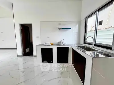 Modern kitchen with sleek countertops and large windows for natural light.