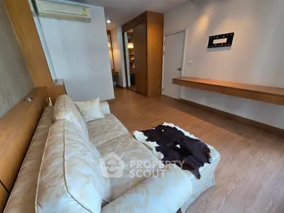 Spacious living room with elegant sofa and modern decor in a stylish apartment.