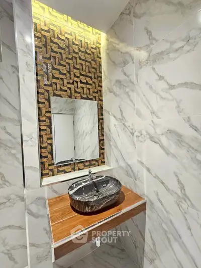 Elegant bathroom with marble walls and stylish sink in modern real estate property.