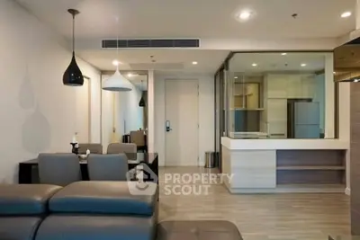 Modern open-plan living room with sleek furniture and stylish lighting in a contemporary apartment.