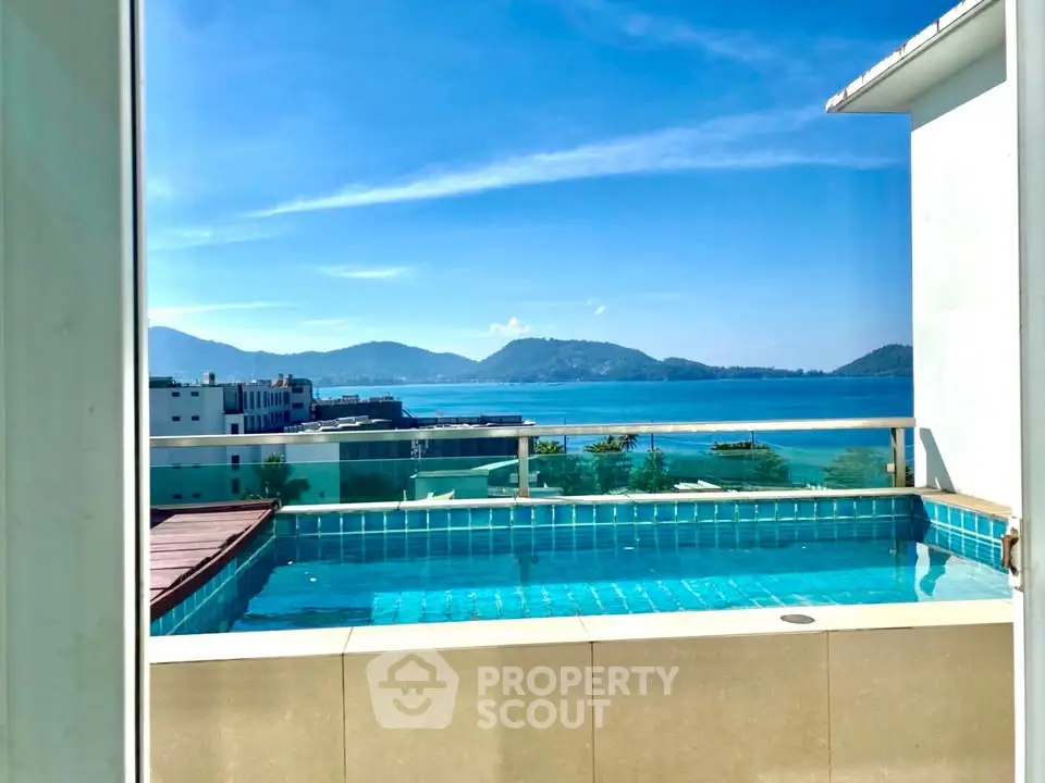 Stunning rooftop pool with breathtaking ocean view and mountains in the background.