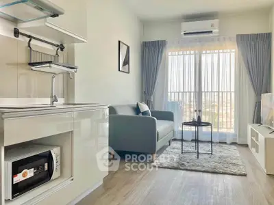 Modern living room with sleek kitchen, cozy sofa, and large window offering natural light.