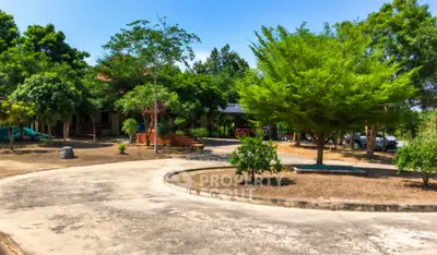 Spacious garden area with lush greenery and ample parking space in a serene residential setting.