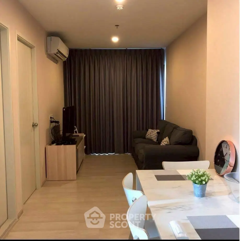 Modern living room with cozy sofa, air conditioning, and dining area in a stylish apartment.