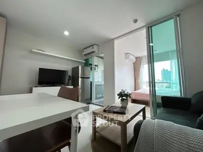 Modern apartment interior with open living room and kitchen, featuring a cozy bedroom view.