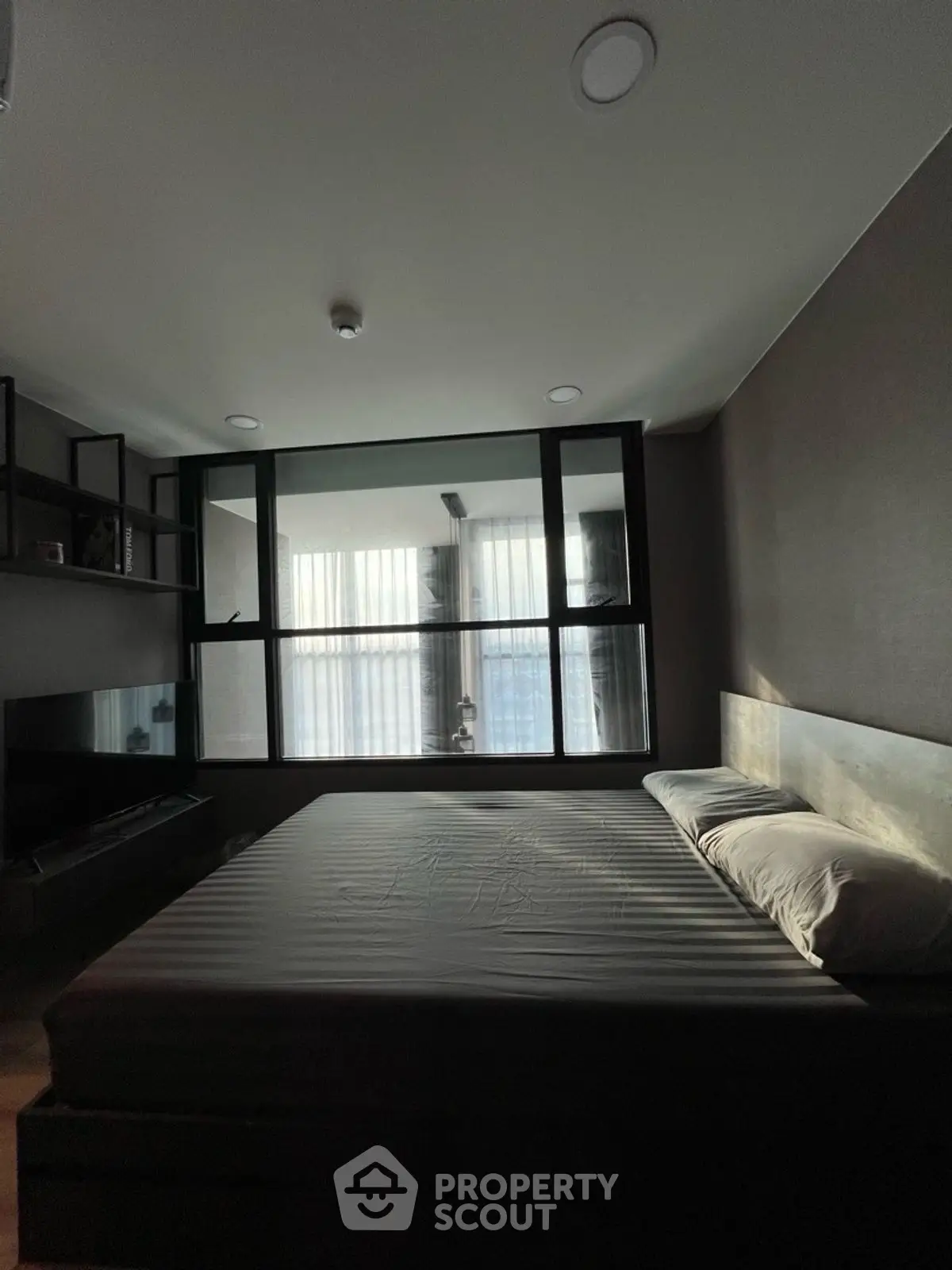 Modern bedroom with large window and minimalist design