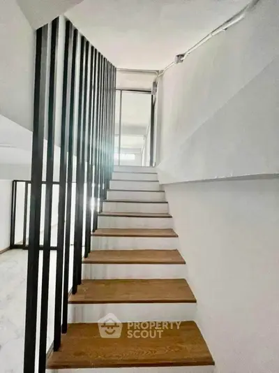 Modern staircase with sleek design and wooden steps in a contemporary home.