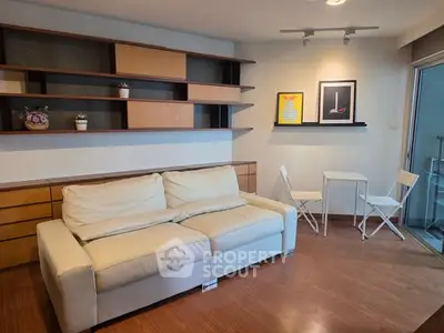 Modern living room with white sofa, wooden flooring, and stylish shelving.
